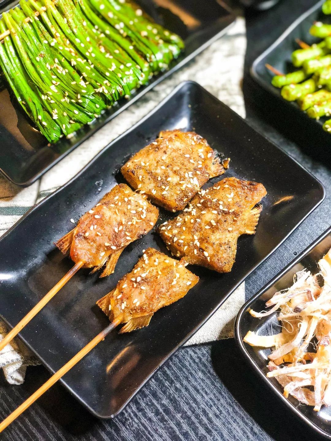 刚烤完的鱼鳍带着热气流油, 肥厚的鱼腩肉经过烟火的洗礼开始燃烧