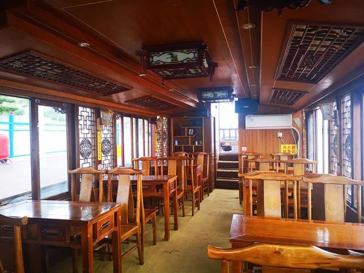 梁画栋给人古色生香之感画舫内部的装修也是清一色的仿古建筑木色桌椅