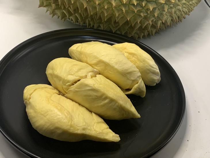 肥美绵软, 仿佛被一层油光水滑的膜包裹着 用叉子把榴莲块装到盘里