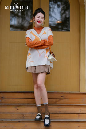 活力橙与白毛衣的碰撞，打破严肃气质，经典百褶裙，重温学院时代。撕掉古板标签