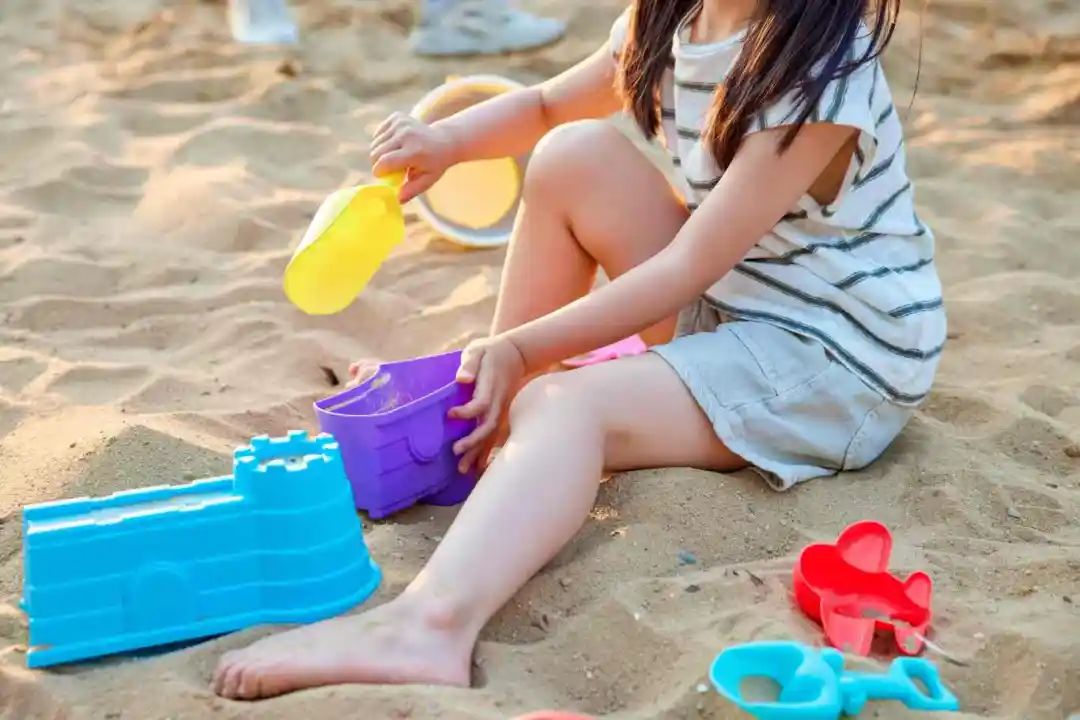 摄图网_507745306_女孩在沙滩上挖沙子特写(企业商用).jpg