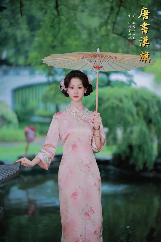 【花朝】精选柔滑缎面，淡雅粉色底衬水墨花卉，七分袖设计雅致婉约，传统立领搭配珍珠配饰更显温婉。修身剪裁勾勒东方女性柔美身姿，漫步园林时撑一柄油纸伞，尽展民国大家闺秀的古典风韵，演绎复古优雅之美。 商品图0