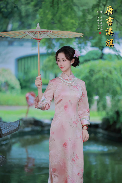 【花朝】精选柔滑缎面，淡雅粉色底衬水墨花卉，七分袖设计雅致婉约，传统立领搭配珍珠配饰更显温婉。修身剪裁勾勒东方女性柔美身姿，漫步园林时撑一柄油纸伞，尽展民国大家闺秀的古典风韵，演绎复古优雅之美。 商品图1