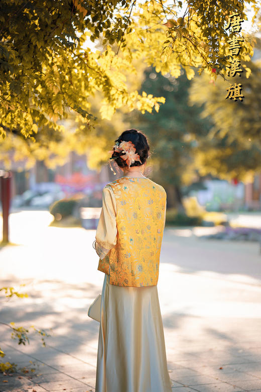 【凌霄（醋酸提花）】衣身以明黄为底，满幅暗织蓝调花蝶提花纹理，古典雅致；门襟缀青蓝盘扣，细节处尽显中式巧思，短款版型适配多元内搭，可叠穿衬衣、高领衫打造层次。 商品图4