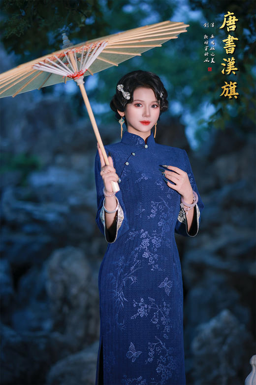 【蓝韵蝶雅】藏蓝提花旗袍立领缀温润玉扣，七分袖口饰精致绣边，尽显复古温婉；提花面料暗织花蝶竹影，朦胧诗意漫溢衣身，修身剪裁勾勒东方曲线，开衩设计更添步履灵秀。 商品图0