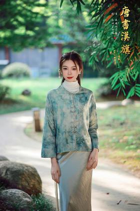 【青花灰影（人丝提花）】青釉色提花中式短衫，萃取国风雅致，点亮日常穿搭意境。   衣身以清润青釉色为底，暗织雅致提花纹理，圆领设计衬出颈部温婉线条；门襟缀传统盘扣，长袖翻折整体版型宽松有度