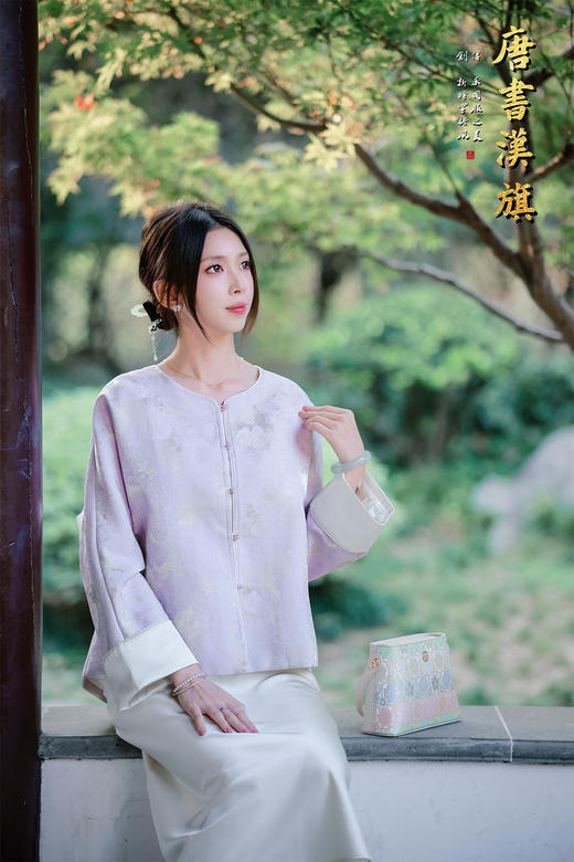 【烟紫黄鹤云（织锦缎）】紫调提花中式短衫，揉碎烟霞入衣袂，焕新国风日常感。   衣身以柔雾紫为底，暗织云纹提花，朦胧间尽显古典雅致；圆领设计衬出颈部线条，门襟缀精致彩扣，袖口翻折浅灰缎面 商品图7