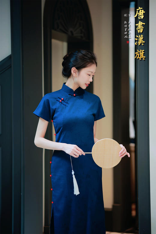 【远山黛】藏青提花旗袍高领剪裁衬出颈部线条，侧襟红珠盘扣添复古灵韵，短袖设计适配多场景穿搭；提花面料暗蕴精致纹理，修身廓形勾勒曼妙曲线，开衩细节更显步履风情。 商品图6