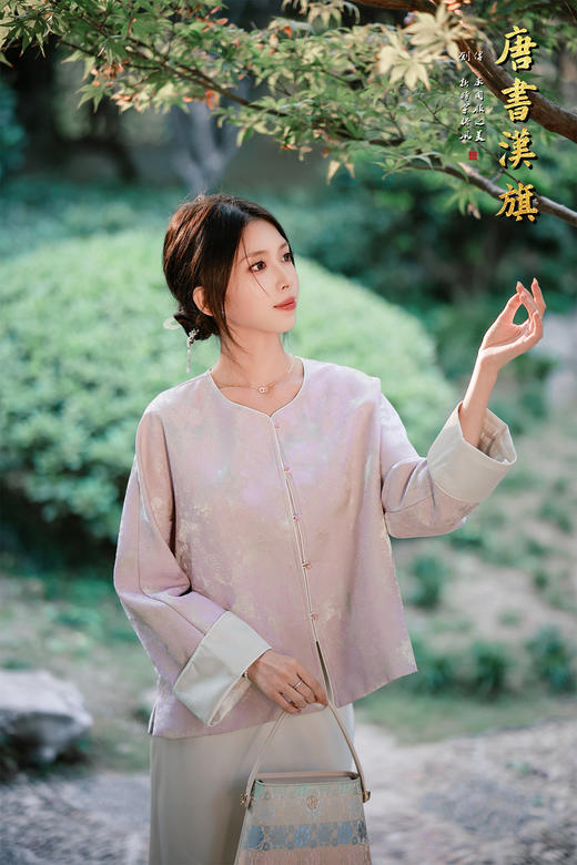 【烟紫黄鹤云（织锦缎）】紫调提花中式短衫，揉碎烟霞入衣袂，焕新国风日常感。   衣身以柔雾紫为底，暗织云纹提花，朦胧间尽显古典雅致；圆领设计衬出颈部线条，门襟缀精致彩扣，袖口翻折浅灰缎面 商品图5