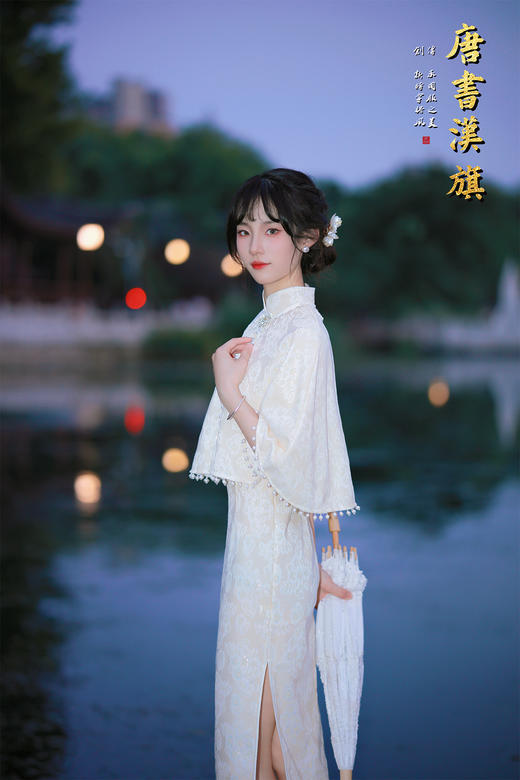 【琉璃梦】月光白提花旗袍套装，以月光白提花面料裁就，领口缀水钻花饰，下摆垂坠珍珠流苏，举手投足间流光轻晃；内搭同色系提花旗袍，修身廓形勾勒曼妙曲线，暗纹织就的清透花纹在光影下若隐若现。 商品图2