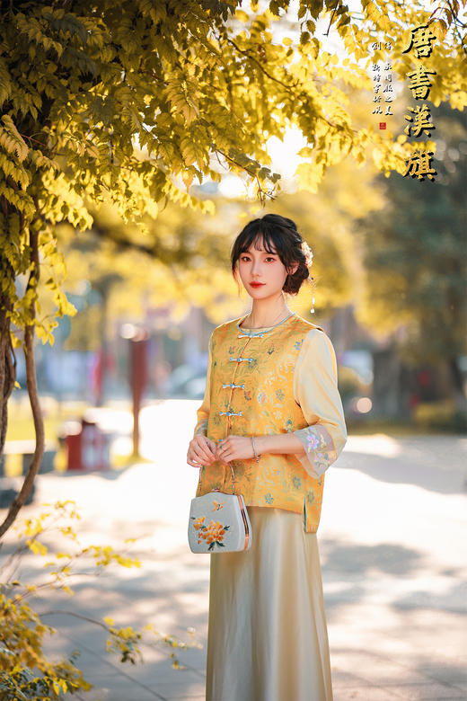 【凌霄（醋酸提花）】衣身以明黄为底，满幅暗织蓝调花蝶提花纹理，古典雅致；门襟缀青蓝盘扣，细节处尽显中式巧思，短款版型适配多元内搭，可叠穿衬衣、高领衫打造层次。 商品图3