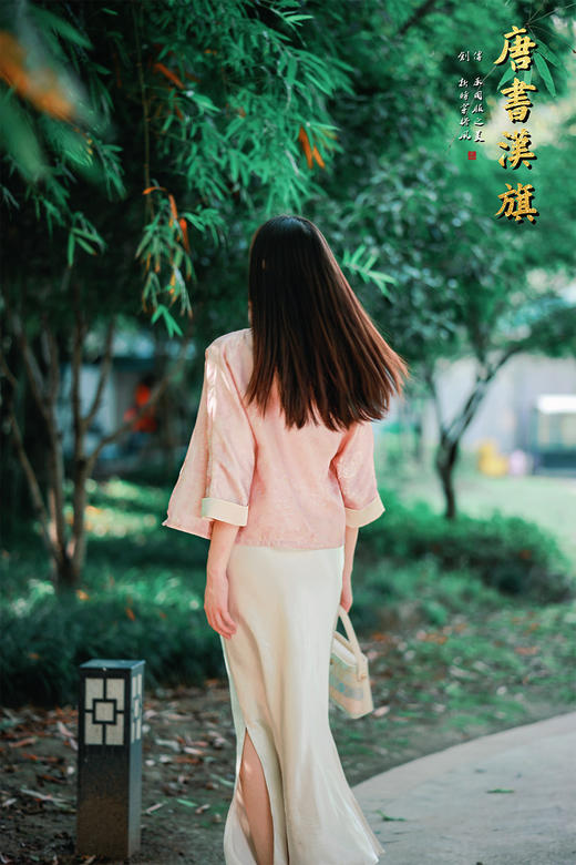 【丝语花痕(人丝提花）】粉调提花短款衬衣，融国风雅致于现代剪裁。   衣身采柔粉提花面料，暗蕴细腻纹理，圆领设计衬得颈部线条温婉；精致花扣点缀门襟，七分袖口饰浅香槟色滚边，细节处尽显复古巧思。 商品图7