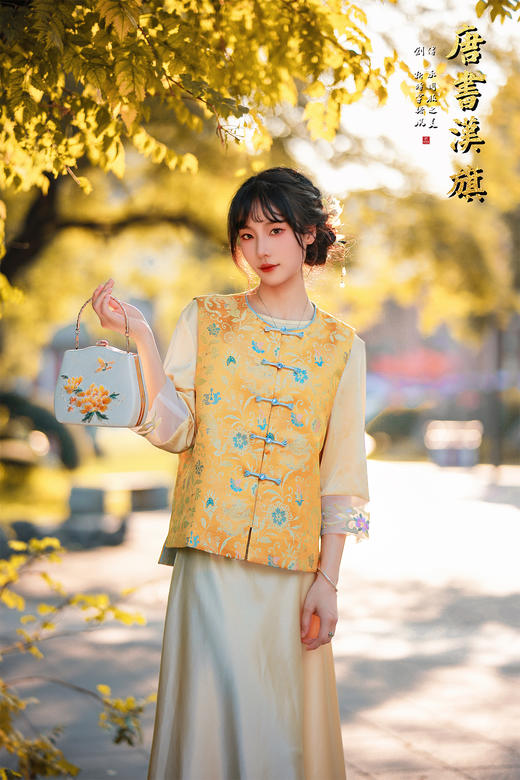 【凌霄（醋酸提花）】衣身以明黄为底，满幅暗织蓝调花蝶提花纹理，古典雅致；门襟缀青蓝盘扣，细节处尽显中式巧思，短款版型适配多元内搭，可叠穿衬衣、高领衫打造层次。 商品图2
