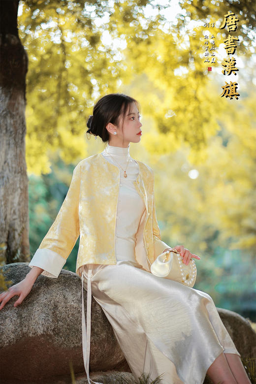 【烟紫黄鹤云（织锦缎）】鹅黄提花中式短衫，撷取国风雅意，焕新日常穿搭。   衣身以柔润鹅黄为底，暗织精致提花纹理，圆领设计衬出颈部温婉线条；门襟缀质感纽扣，七分袖口翻折浅香槟色缎面 商品图1