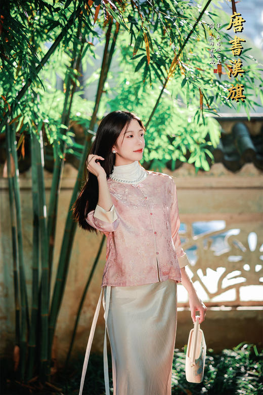 【丝语花痕(人丝提花）】粉调提花短款衬衣，融国风雅致于现代剪裁。   衣身采柔粉提花面料，暗蕴细腻纹理，圆领设计衬得颈部线条温婉；精致花扣点缀门襟，七分袖口饰浅香槟色滚边，细节处尽显复古巧思。 商品图5