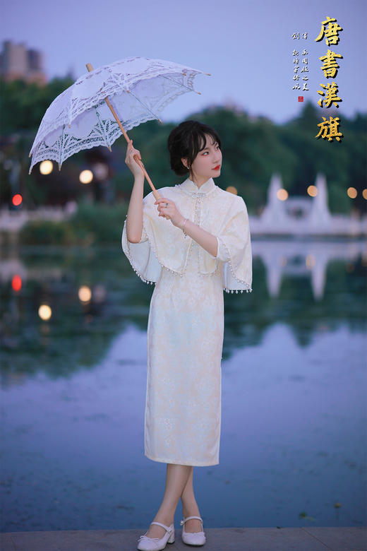 【琉璃梦】月光白提花旗袍套装，以月光白提花面料裁就，领口缀水钻花饰，下摆垂坠珍珠流苏，举手投足间流光轻晃；内搭同色系提花旗袍，修身廓形勾勒曼妙曲线，暗纹织就的清透花纹在光影下若隐若现。 商品图5