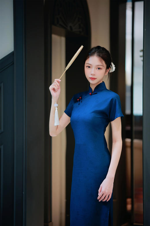 【远山黛】藏青提花旗袍高领剪裁衬出颈部线条，侧襟红珠盘扣添复古灵韵，短袖设计适配多场景穿搭；提花面料暗蕴精致纹理，修身廓形勾勒曼妙曲线，开衩细节更显步履风情。 商品图5