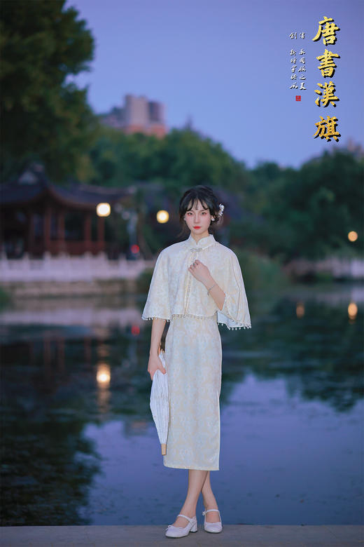 【琉璃梦】月光白提花旗袍套装，以月光白提花面料裁就，领口缀水钻花饰，下摆垂坠珍珠流苏，举手投足间流光轻晃；内搭同色系提花旗袍，修身廓形勾勒曼妙曲线，暗纹织就的清透花纹在光影下若隐若现。 商品图1