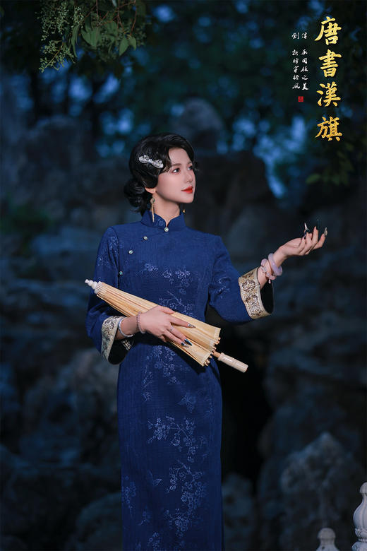 【蓝韵蝶雅】藏蓝提花旗袍立领缀温润玉扣，七分袖口饰精致绣边，尽显复古温婉；提花面料暗织花蝶竹影，朦胧诗意漫溢衣身，修身剪裁勾勒东方曲线，开衩设计更添步履灵秀。 商品图3