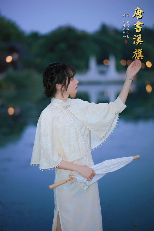 【琉璃梦】月光白提花旗袍套装，以月光白提花面料裁就，领口缀水钻花饰，下摆垂坠珍珠流苏，举手投足间流光轻晃；内搭同色系提花旗袍，修身廓形勾勒曼妙曲线，暗纹织就的清透花纹在光影下若隐若现。 商品图7