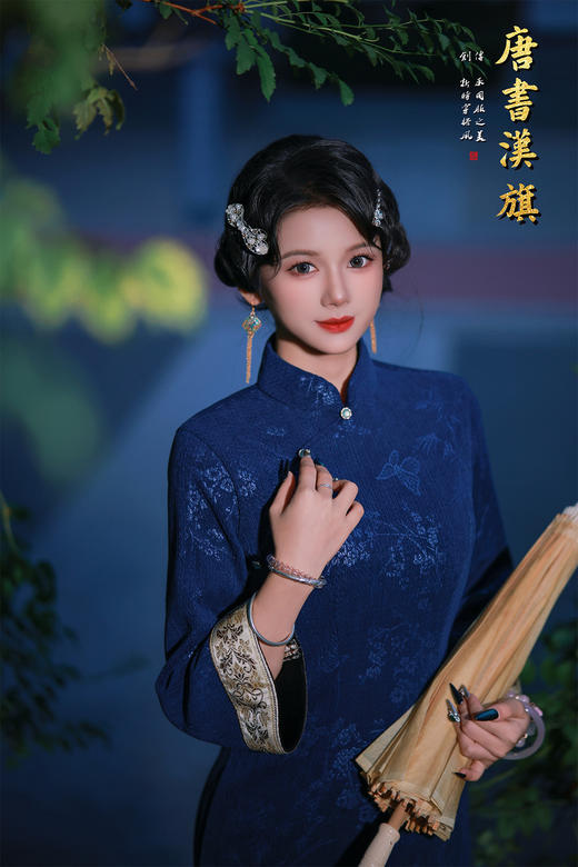 【蓝韵蝶雅】藏蓝提花旗袍立领缀温润玉扣，七分袖口饰精致绣边，尽显复古温婉；提花面料暗织花蝶竹影，朦胧诗意漫溢衣身，修身剪裁勾勒东方曲线，开衩设计更添步履灵秀。 商品图1