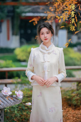 【雾蓝绣影】新中式立领盘扣造型，领口与袖口拼接毛绒边，裙身缀有淡雅花卉刺绣，下摆蕾丝花边点缀，修身剪裁勾勒温婉身形，米白色调清新雅致