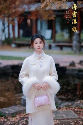 【素白兰烟（澳洲超细羊毛）】新中式立领盘扣造型，衣身缀有精致刺绣图案，袖口拼接蓬松毛绒，宽松廓形包容各种身形，米白色调温柔雅致，尽显东方古典韵味。